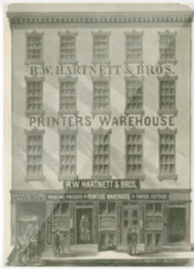 A black-and-white illustration of a four-story building labeled "R.W. Hartnett & Bros. Printers' Warehouse." The ground floor features shop windows and a sign above the entrance, highlighting the legacy of Ackley Hartnett in printing.