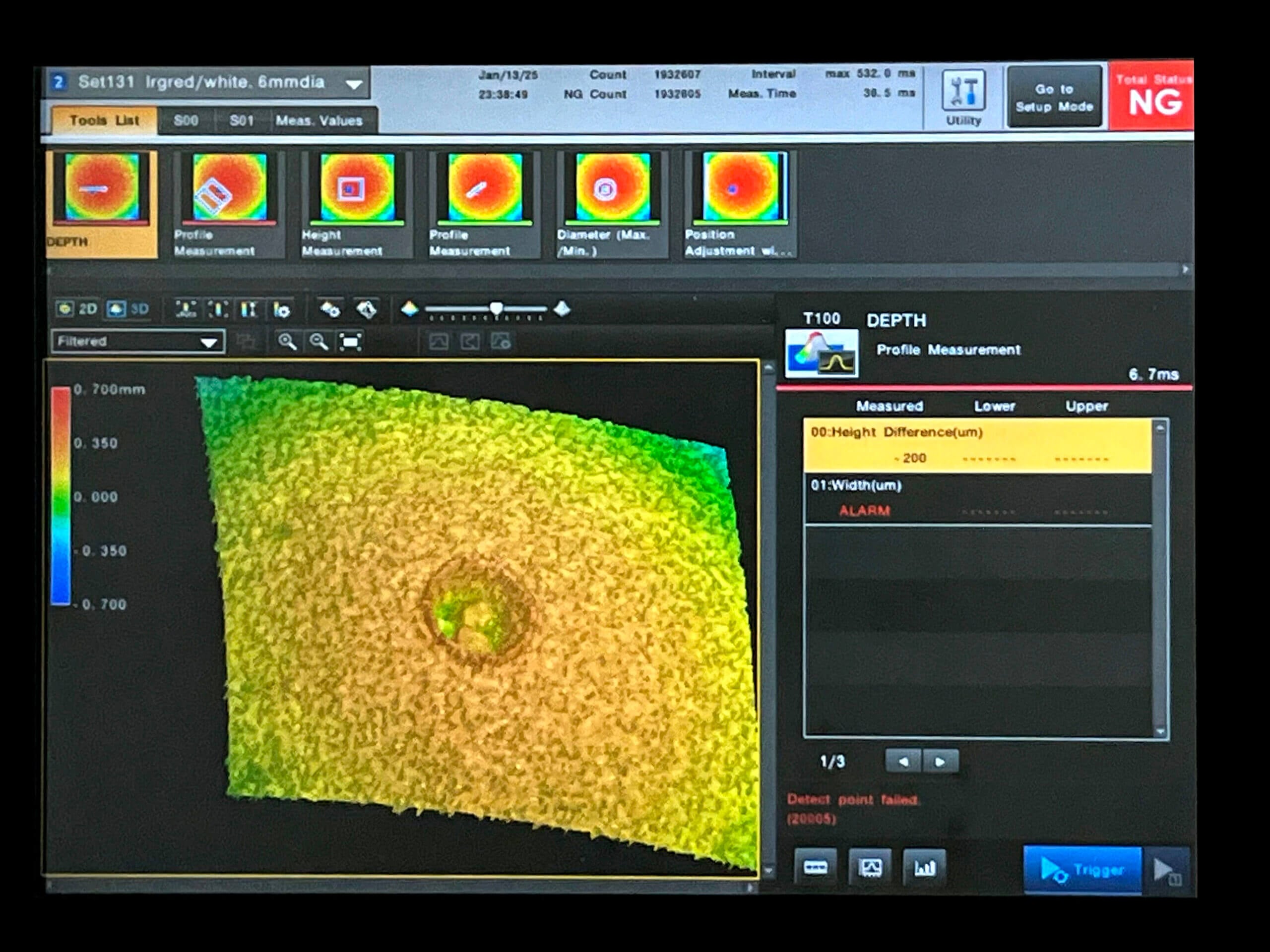 A computer screen displays a 3D surface profile measurement with a color-coded height map, graphs, and tools—typical of inspection machines for pharmaceuticals—plus an alarm notification on the right indicating a height difference issue.