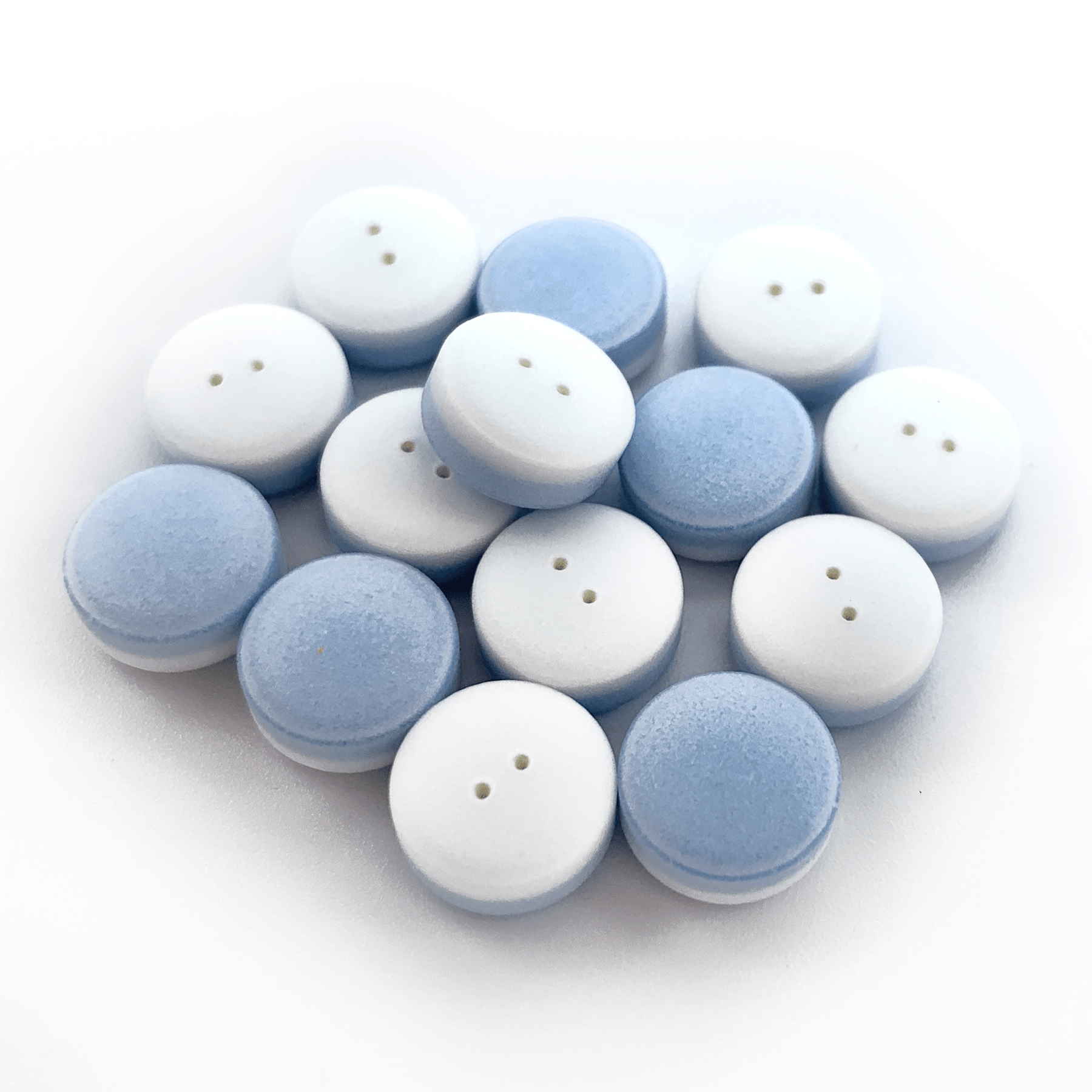 Laser Drilled sample product blue on one side and white on the other with two holes