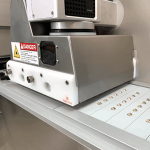 Softgels being laser marked in Ackley's Cantilever Ramp Laser Printing Machine